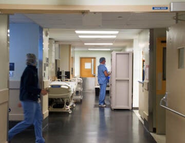 Medical professionals walk in hallways outside of an operating room.