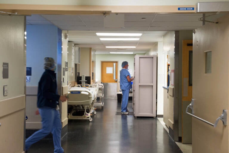 Medical professionals walk in hallways outside of an operating room.