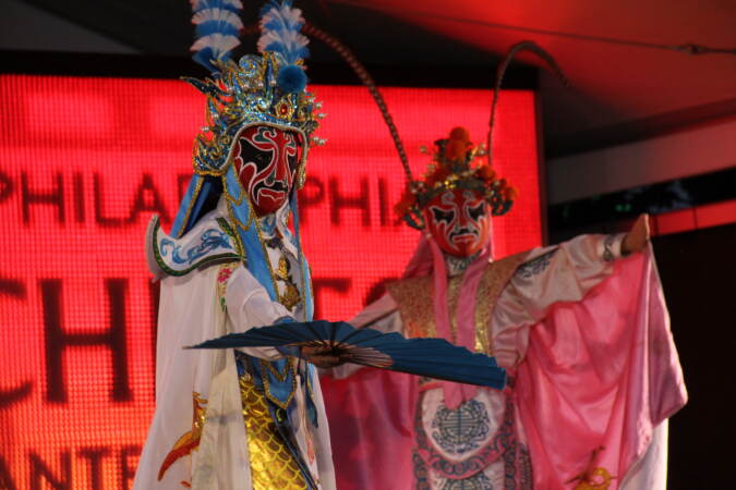 Performers on stage in full mask and costume.