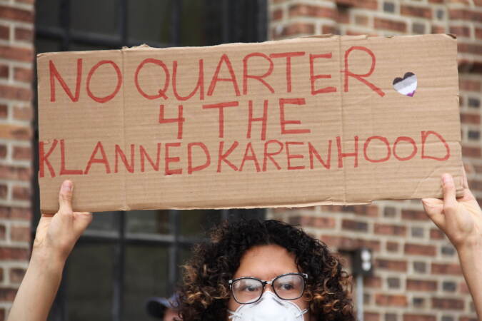 A person holds up a sign that reads 