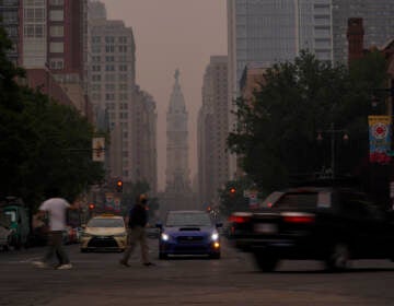 Evening commuters travel on Broad Street past a hazy City Hall, Wednesday, June 7, 2023, in Philadelphia.