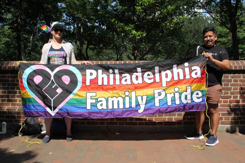 2 people holding a 'Philadelphia Family Pride' flag