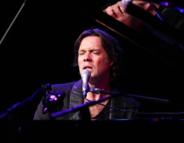 Rufus Wainwright sings while playing the piano.