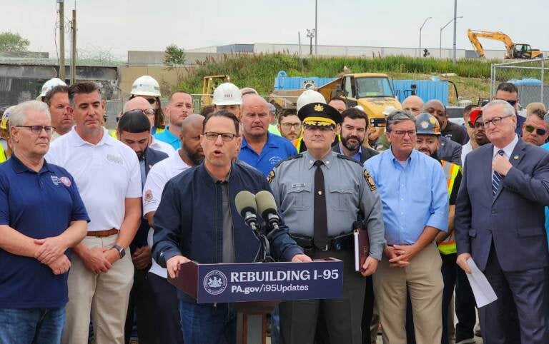 Josh Shapiro speaking at a podium at the collapse site.