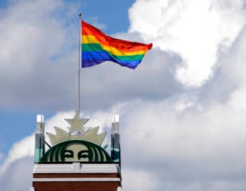 A Pride Flag flies on top of the Starbucks logo on top of the company's headquarters in Seattle.