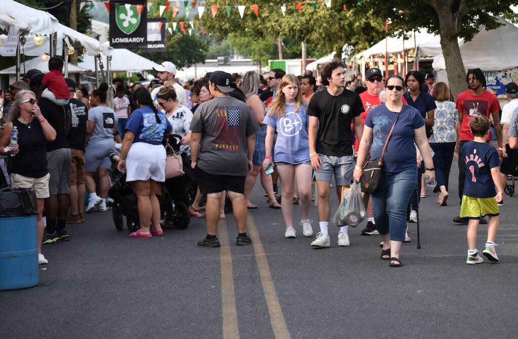 People walk on the street at a festival.