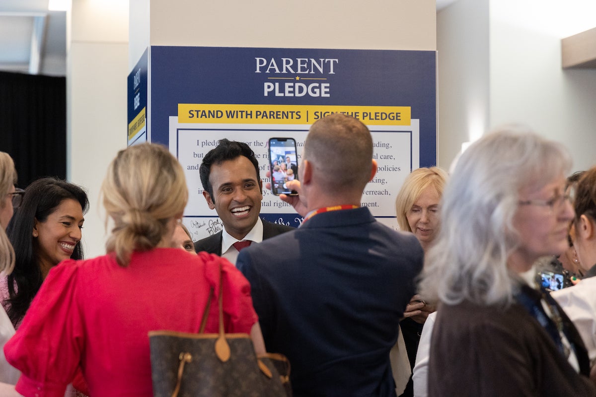 Republican presidential candidate Vivek Ramaswamy smiles as he speaks with people.