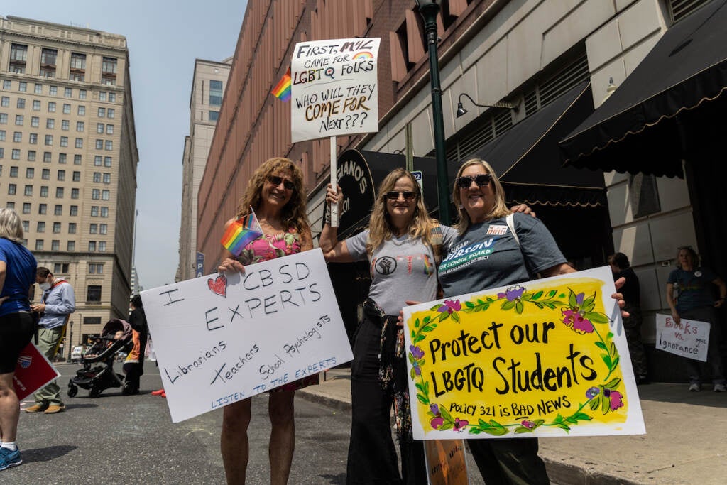 Bucks County residents Ellen Lesh (left), Kira Kraiman (center) and Amy Mcgahran (right) hold signs supporting LGBTQ students.