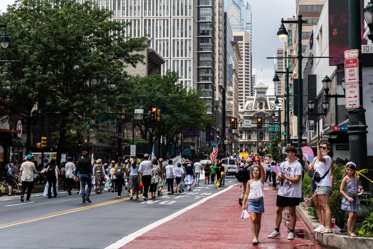 People wave U.S. flags on Market Street as the parade goes by.