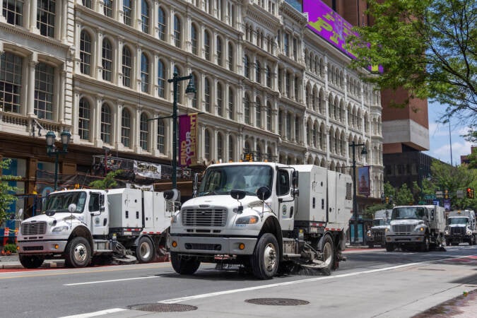 A fleet of city street sweepers rolls through Market Street