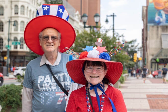 Cheryl Gunter (right) and Paul Rabe (left) wear Fourth of July decorations as they pose for a photo on Market Street.