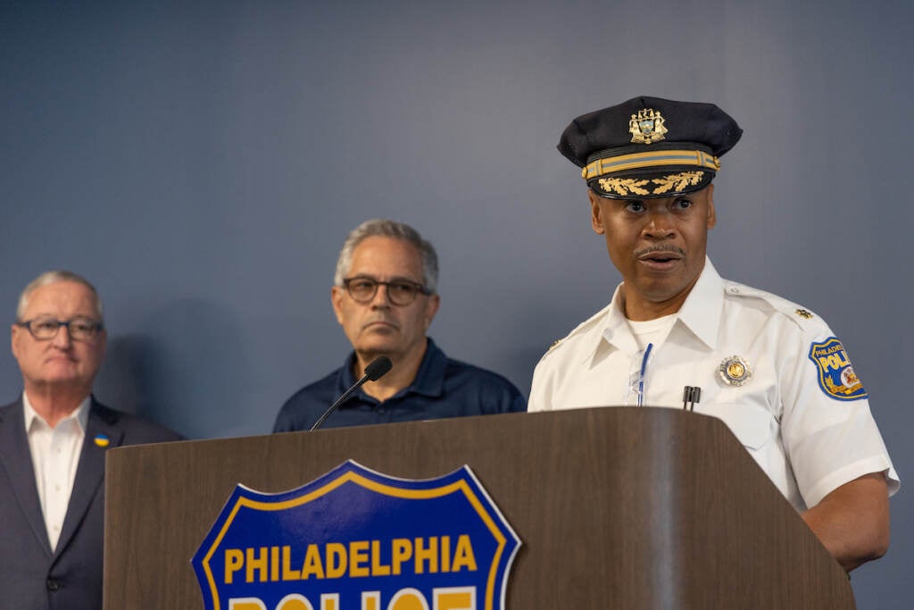 Philadelphia Homicide Division Staff Inspector Ernest Ransom speaks at a podium. Mayor Kenney and DA Krasner look on behind him.