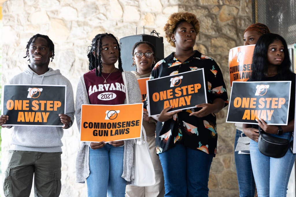 Young people hold pro-gun control signs at a press conference.