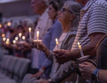 A close-up of people holding candles at a vigil in Upper Makefield.