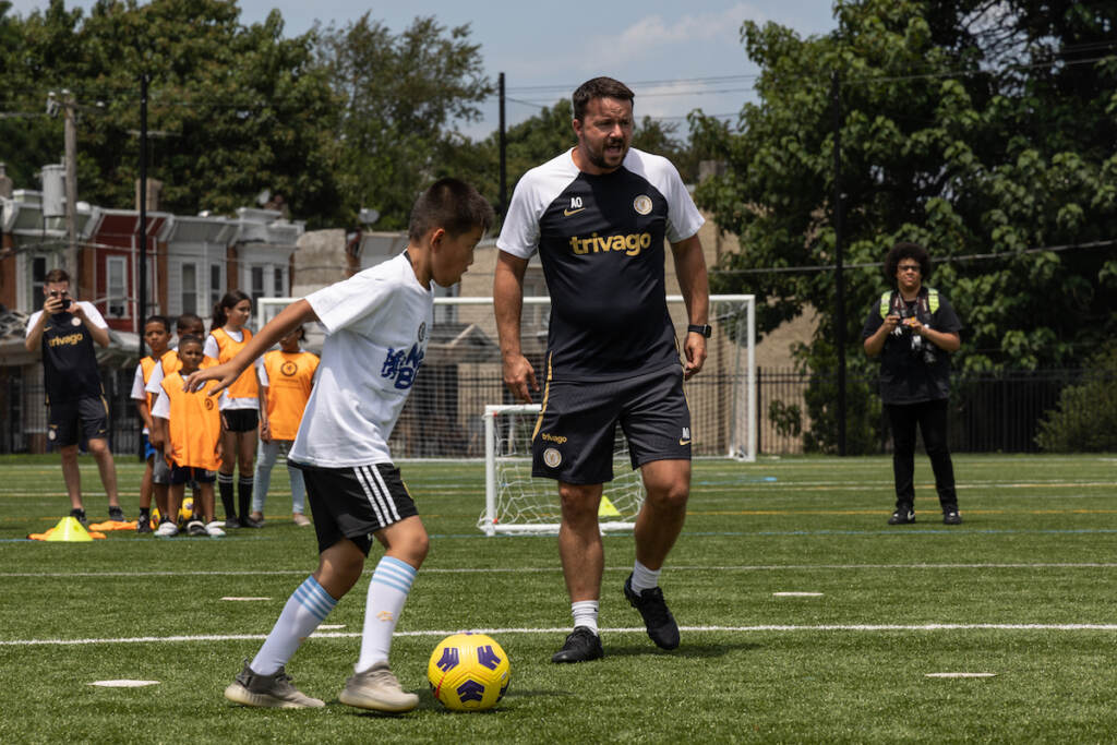 Chelsea FC U14 Head Coach Andy Ottley gives instructions during a soccer clinic at Christo Rey High School on July 24, 2023