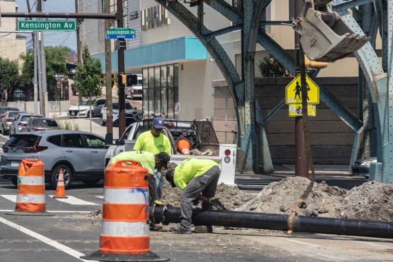 Construction workers work in the heat on Kensington Avenue