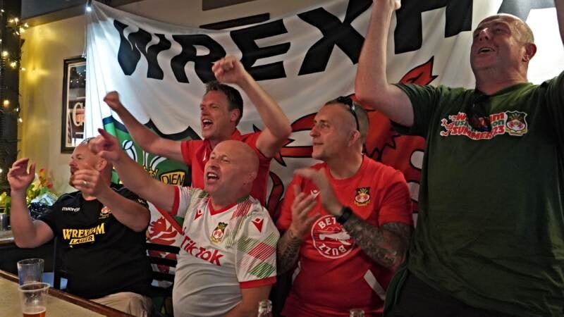 Fans of Welsh side Wrexham sing against the other side of the bar at Mac's Tavern on Thursday, July 27, 2023