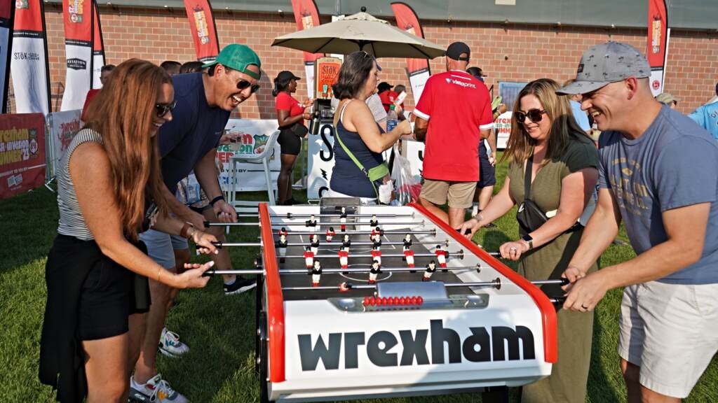 A group of fans play foosball in the Wrexham fan zone ahead of the Welsh side's game against the Union II