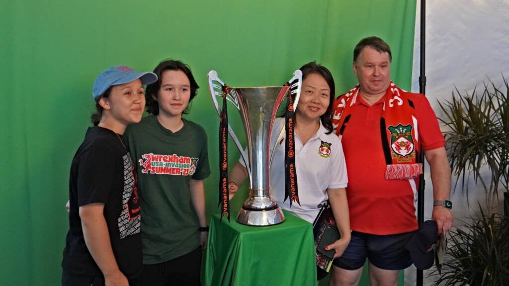 Fans got a chance to pose with Wrexham's National League trophy in the fan zone outside Subar uPark. Photos of the Welsh side's celebrations in April were being handed out, as well as booklets of the official Wrexham chants, with curse words redacted by black bars