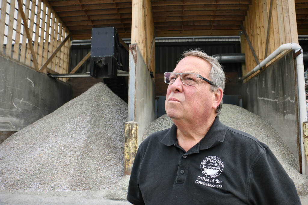 Burlinton County Commissioner Tom Pullion stands before piles of crushed glass at the county recycling facility in Westampton