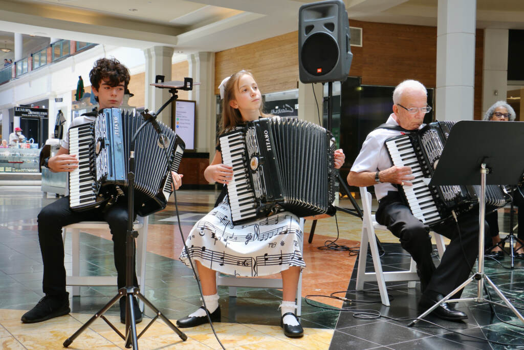 Caroline Lammers,(center), plays accordion with her cousin, Nicholas Busso (left), and their grandfather, Frank Busso Sr.