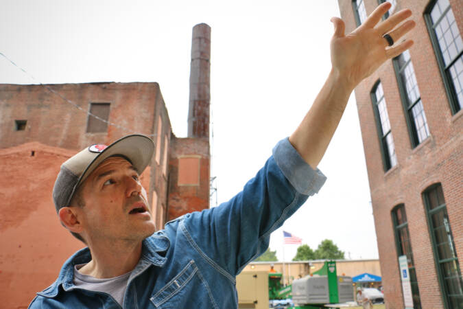 Casey O’Donnell speaking while looking at the building.