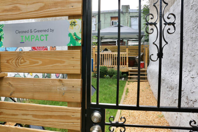 A view at a backyard with a sign that says 'Cleaned and Greened by IMPACT'