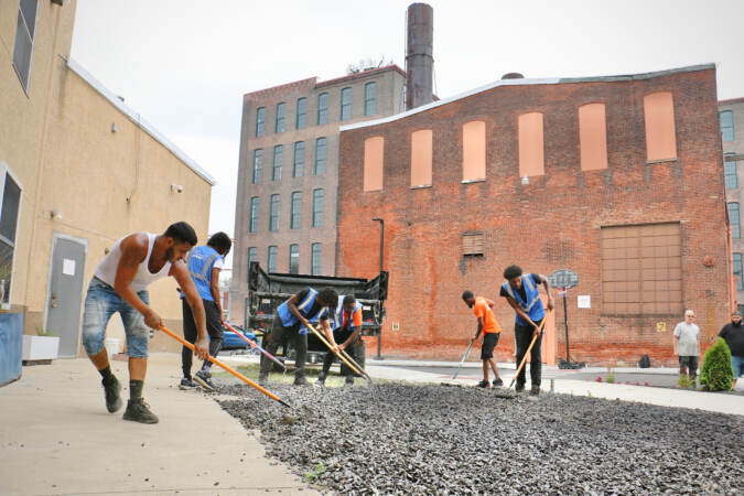 People spreading gravel on the ground.