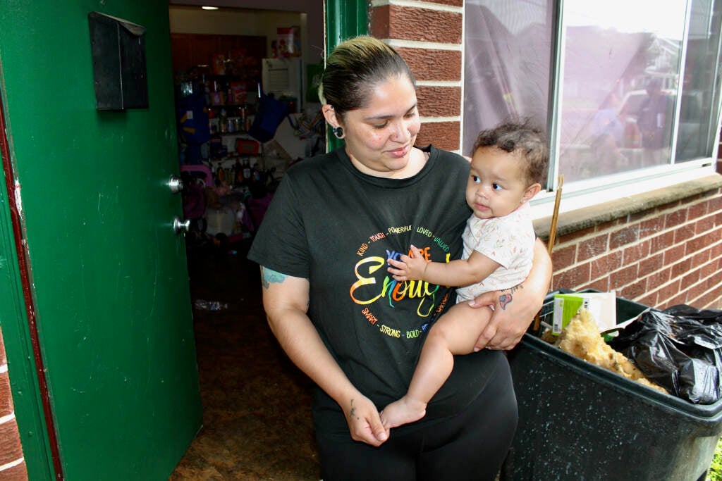 Jasmine Vega holds her infant daughter outside of their apartment