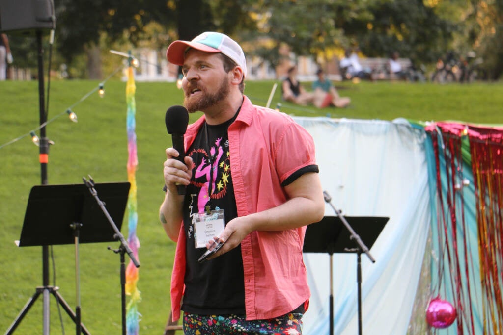 Shamus McCarty speaks into a microphone at Clark Park.