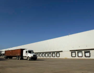 A truck drives past loading docks at a distribution center
