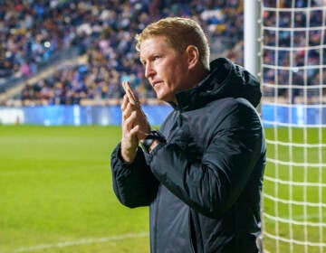 Philadelphia Union head coach Jim Curtin reacts to the crowd as he heads onto the field during the first half of an MLS playoff soccer match against the Nashville SC