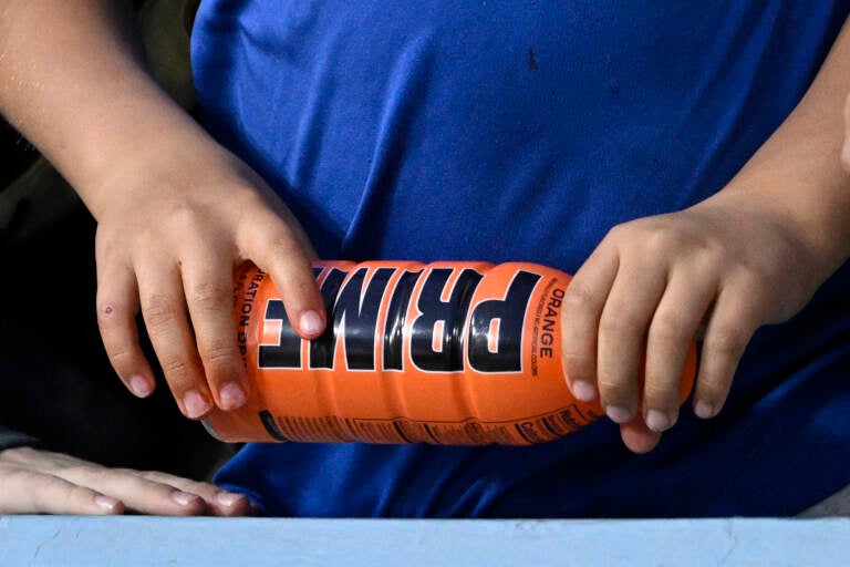 A child holds a PRIME hydration drink prior to a baseball game between the Los Angeles Dodgers and the Arizona Diamondbacks, March 31, 2023, in Los Angeles