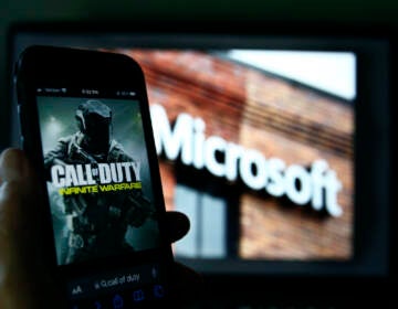 File photo: An image from Activision's Call of Duty is shown on a smartphone near a photograph of the Microsoft logo in this photo taken in New York, Thursday, June 15, 2023.