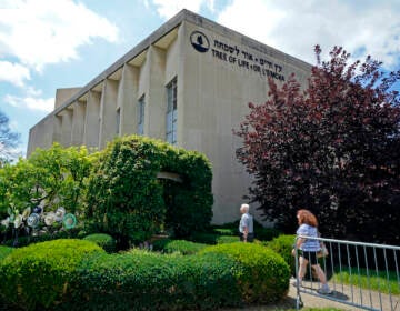 People walk outside the dormant landmark Tree of Life synagogue in Pittsburgh's Squirrel Hill neighborhood on Thursday, July 13, 2023, the day a federal jury announced they had found Robert Bowers, who in 2018 killed 11 people at the synagogue, eligible for the death penalty