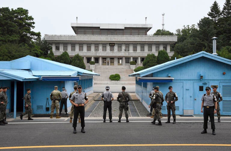 Soldiers of South Korea and the U.S. stand guard during a commemorative ceremony for the 64th anniversary of the signing of the Korean War Armistice Agreement at the truce village of Panmunjom in the Demilitarized Zone (DMZ) dividing the two Koreas, on July 27, 2017.