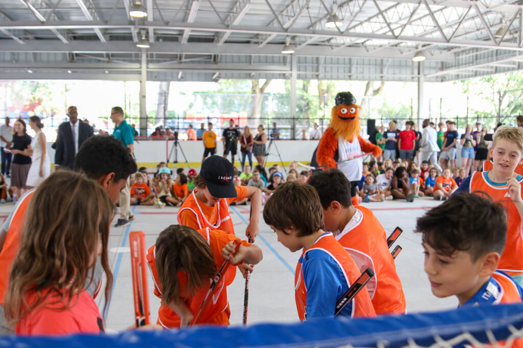 Children play in the new ice rink as Gritty watches on