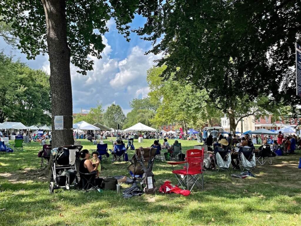 Festival-goers sit in the shade at Saunders Park during the 2023 Lancaster Avenue Jazz and Arts Festival