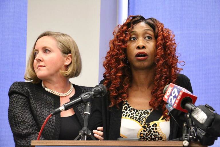 Angel Davis stands at a podium with her lawyer, Bethany Nikitenko