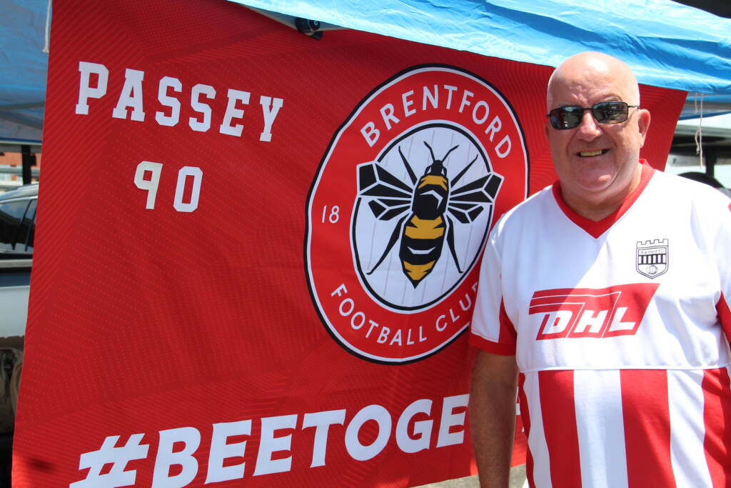 Colin Passey stands in front of a custom banner outside the Premier League Summer Series event at Lincoln Financial Field