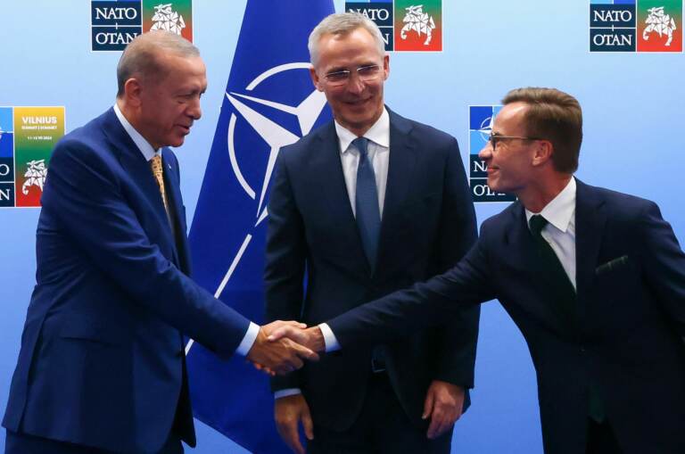 urkish President Tayyip Erdogan (left) and Swedish Prime Minister Ulf Kristersson shake hands in front of NATO Secretary-General Jens Stoltenberg prior to their meeting, on the eve of a NATO summit, in Vilnius, Lithuania, on Monday. (Yves Herman/Pool/AFP via Getty Images)