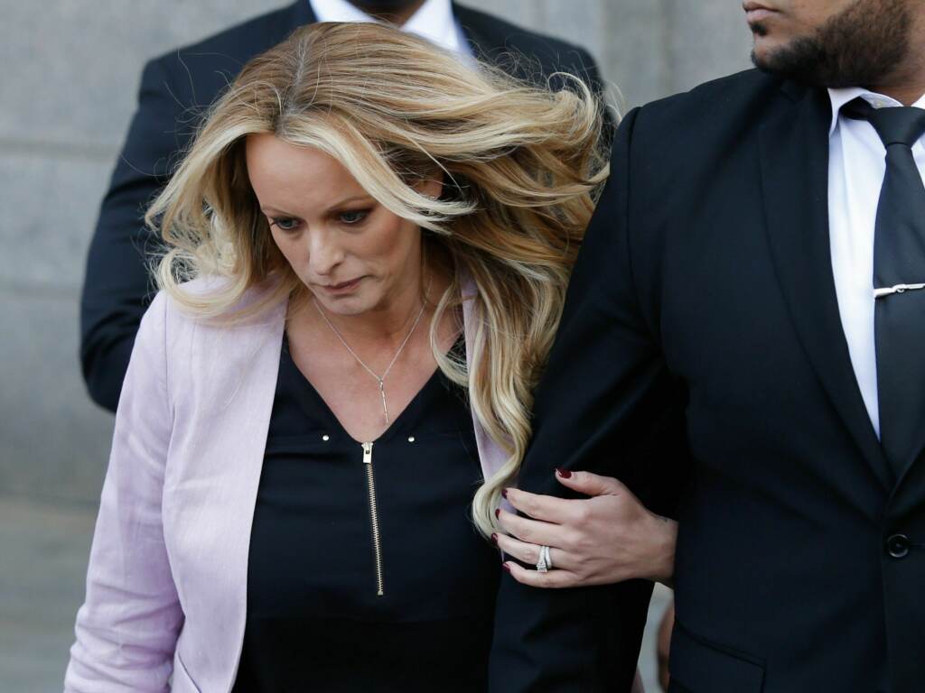 Adult-film actress Stephanie Clifford, also known as Stormy Daniels, walks forward next to another person.