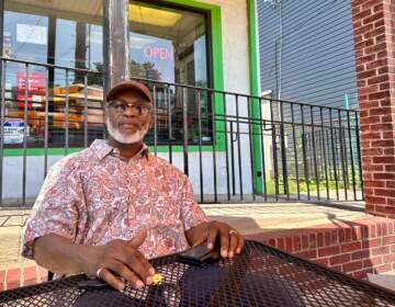 Larry Fletcher sits at a table outside of his restaurant.