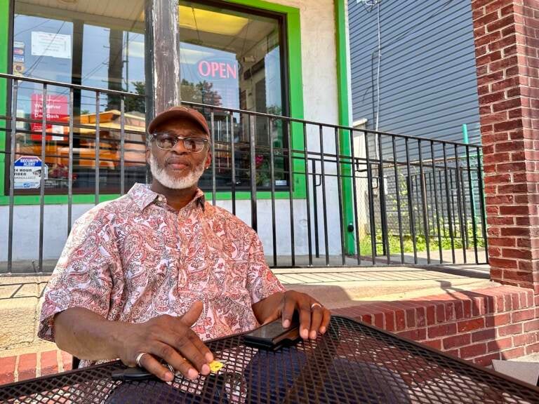 Larry Fletcher sits at a table outside of his restaurant.