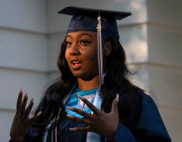 Nylla Miller speaks in a close-up photo. She is wearing her high school graduation cap and gown.