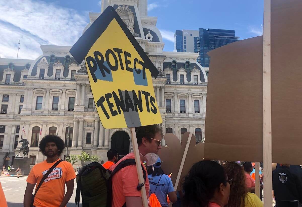 A person holds a sign that reads 