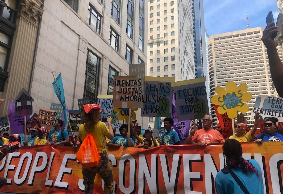 People march with signs in support of affordable housing.