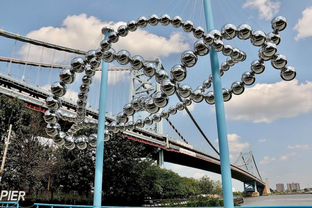 A giant knot sculpture is displayed near the Delaware River.