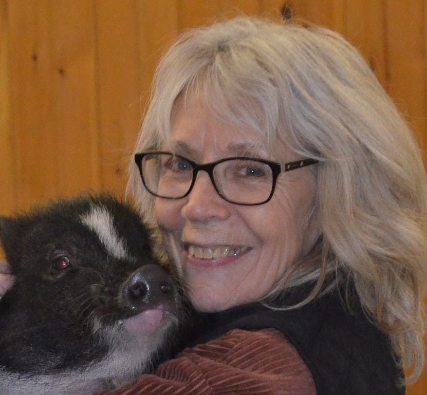 Susan Magidson holding a pig.