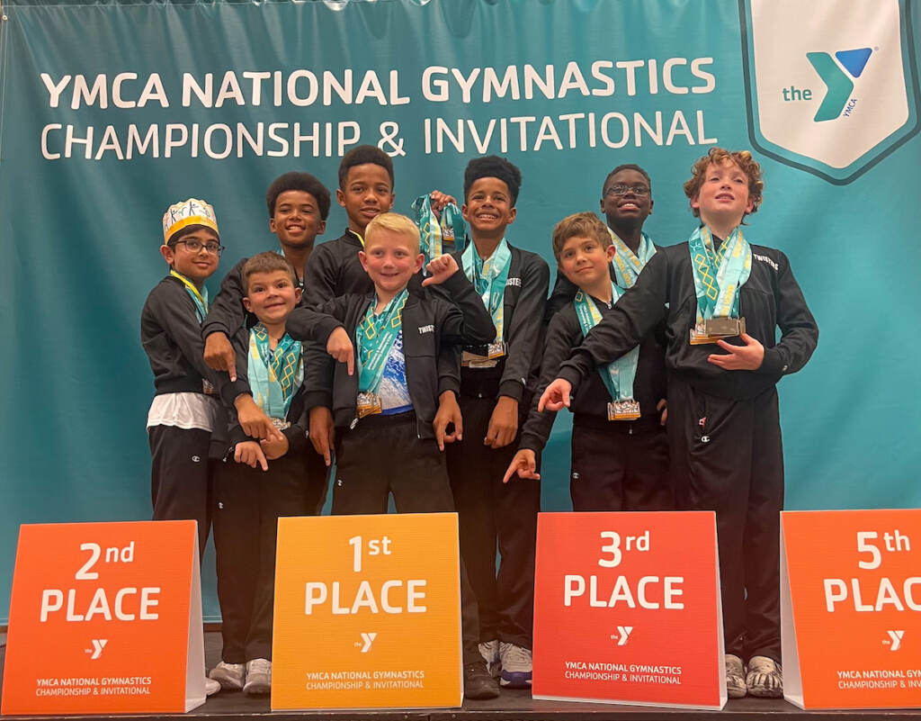 A group of young gymnasts poses for a photo.